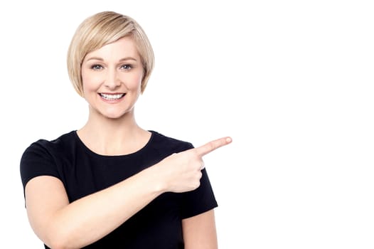 Happy woman pointing her finger to copy space
