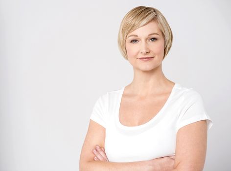 Confident middle aged woman posing with folded arms