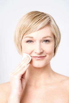 Beautiful woman applying cosmetic with sponge