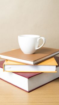 stack of book with coffee cup on wood table background