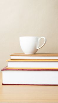 stack of book with coffee cup on wood table background