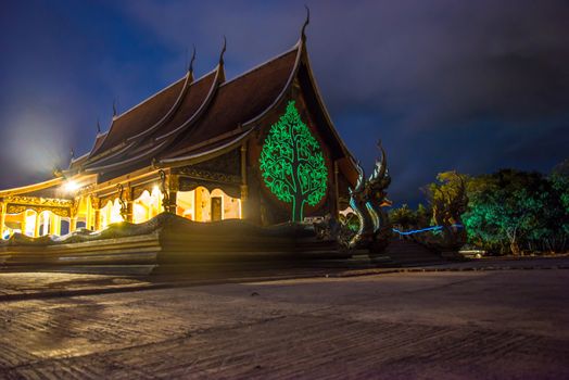 Art tree glow on the back of the hall of the temple in Thailand.