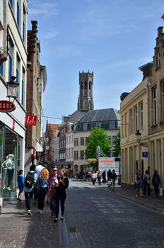 Bruges, Belgium - May 11, 2015: Tourists visit Steenstraat Shopping Street in Bruges, Belgium. Bruges is the capital and largest city of the province of West Flanders in the Flemish Region of Belgium.