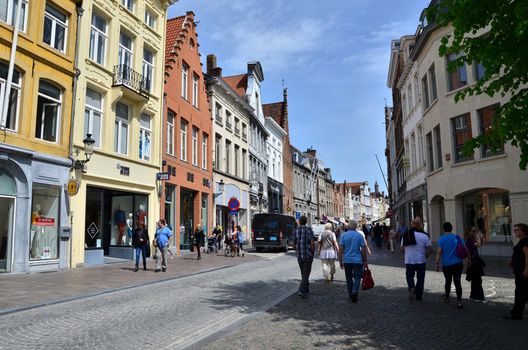 Bruges, Belgium - May 11, 2015: Tourists visit Steenstraat Shopping Street in Bruges, Belgium. Bruges is the capital and largest city of the province of West Flanders in the Flemish Region of Belgium.