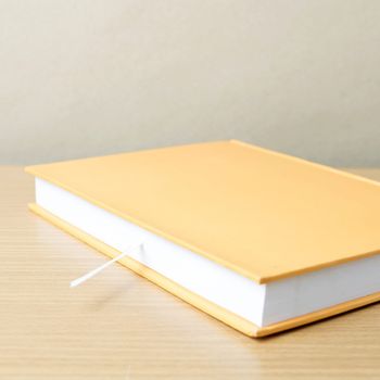 orange book on wood table background