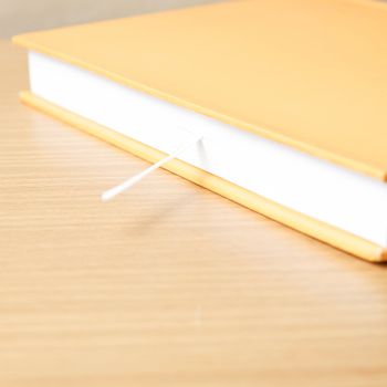 orange book on wood table background