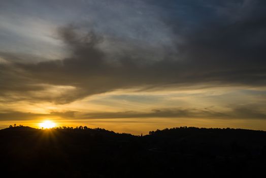 Sunrise in the morning, surrounded by mountains and meadows.
