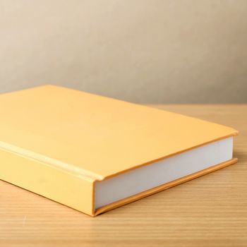 orange book on wood table background
