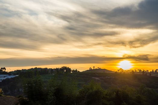 Sunrise in the morning, surrounded by mountains and meadows.