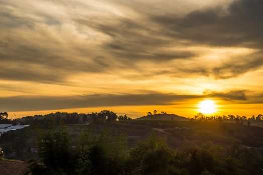 Sunrise in the morning, surrounded by mountains and meadows.