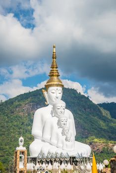 White Buddha statue amidst the mountains in Thailand, wat phasornkaew