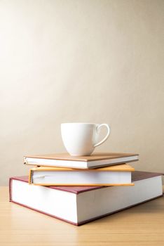 stack of book with coffee cup on wood table background