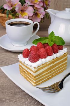 Piece of honey cake with whipped cream and raspberries