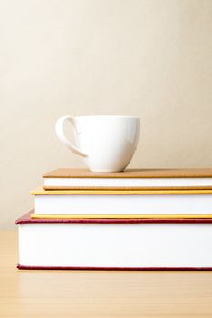 stack of book with coffee cup on wood table background