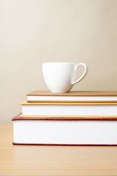 stack of book with coffee cup on wood table background