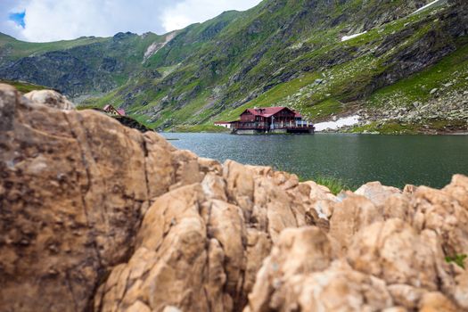 BALEA LAKE, ROMANIA - JUNE 24, 2012: Idyllic view with cottege on Balea Lake shore in Fagaras Mountains, Romania.