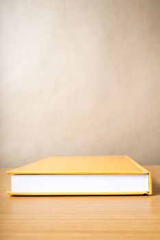 orange book on wood table background