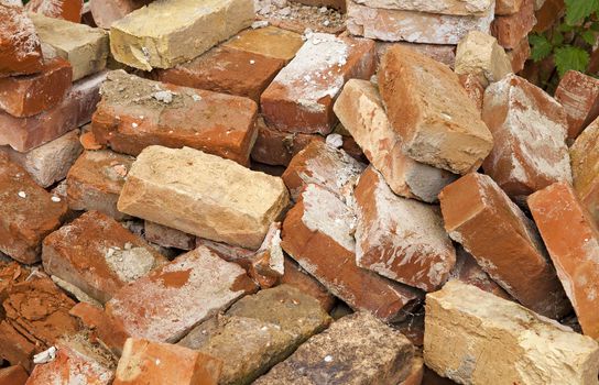   the piled old bricks of red color. were used for construction