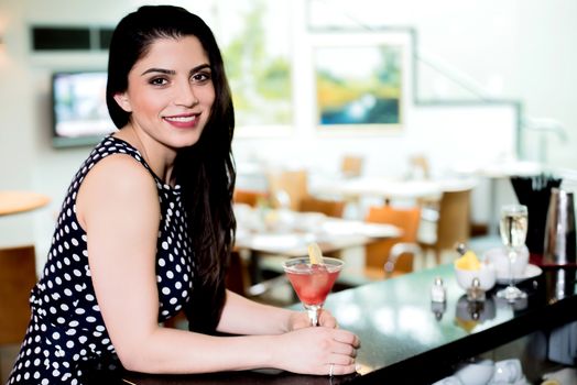 Beautiful woman enjoying a drink on a bar