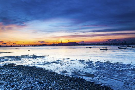 Sunset coast with a bridge connecting opposite side