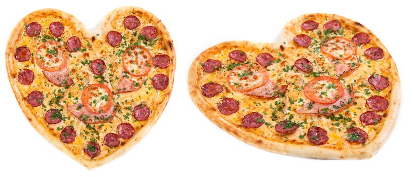 Meat pizza with ham, salami, tomatoes and cheese topped with fresh Italian herbs in heart shape for valentine