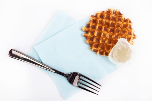 background biscuits, waffles, fruit jelly and fork and napkin isolated on white background