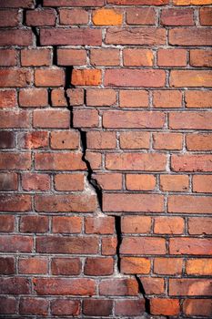 Background texture. The wall of the old red brick with a crack across the wall