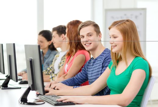 education, technology and internet - smiling male student with computer studying at school