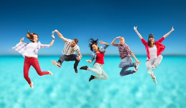 summer, sport, dancing and teenage lifestyle concept - group of teenagers jumping