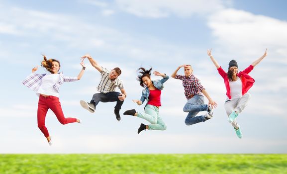 summer, sport, dancing and teenage lifestyle concept - group of teenagers jumping