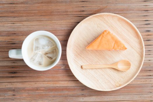 Orange cake and coffee on a wooden table. Orange cake with a spoon for eating.