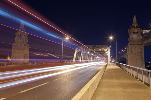 Traffic at night. The light from cars traveling across the bridge at night.