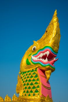 Large golden naga on the blue sky background.
