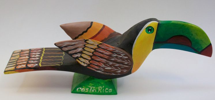 Wood carving with bright colors painted in the shape of a Toucan bird
