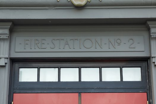 Fire Station No 2 Sign about a red door with windows