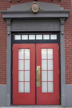 Fire Station No 2 Sign about a red door with windows