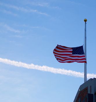 US Flag at half mast on top of a building