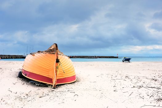 Wooden boat inverted bottom up on the sandy beach