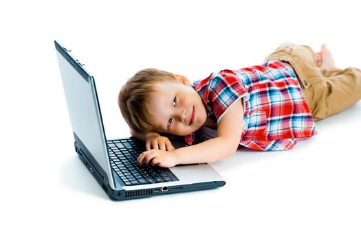 little boy in a plaid shirt with a laptop on a white background.