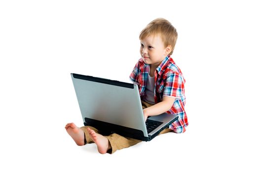 little boy in a plaid shirt with a laptop on a white background.