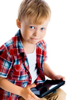 little boy in a plaid shirt with a tablet computer against a white background.