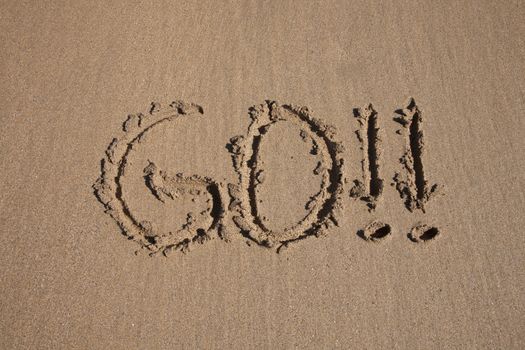 go word written on brown sand ground low tide beach ocean seashore in Spain Europe