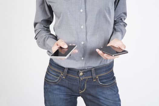 woman blue jeans trousers and grey shirt with mobile phone smartphone blank screen in her both two hands isolated over white background