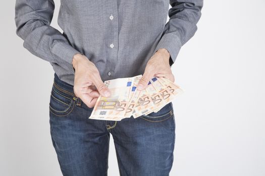 woman blue jeans trousers and grey shirt counting currency money cash fifty Euro banknotes in her hands isolated over white background