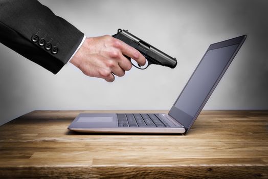 Businessman shoots with gun at his laptop