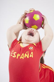 blonde baby sixteen month old and mother with red shirt of Spanish soccer team taking ball