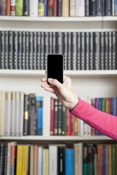 pink jersey woman showing blank smartphone screen at library