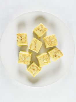 little portions with toothpick of yellow spanish potato omelette on white dish
