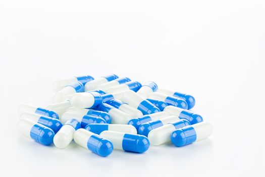 blue and white Pills (Capsules) with Many in Background Isolated on a White background
