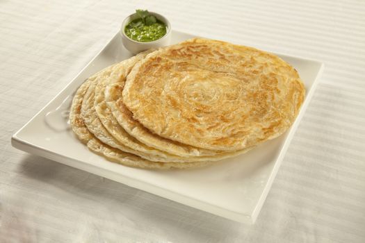 Plain paratha puri served with freshly diced corriander in green chutney